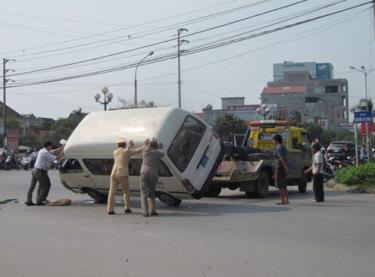 Cảnh sát và lực lượng cứu hộ đưa xe biển xanh ra khỏi hiện trường.