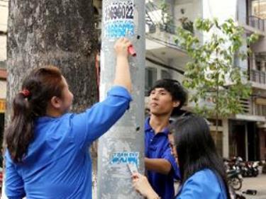 Đoàn viên thanh niên tham gia bóc gỡ rác quảng cáo trên các cột điện.