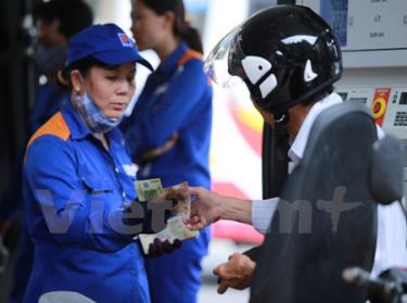 Nhân viên Petrolimex đang bơm xăng cho khách hàng.