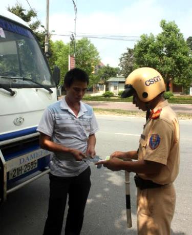 Cảnh sát giao thông huyện Yên Bình kiểm tra giấy phép lái xe người điều khiển phương tiện giao thông.