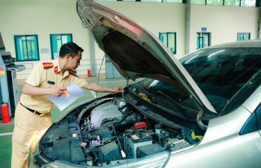 Cán bộ, chiến sĩ CSGT (Bộ Công an) được cử tới hỗ trợ trong hoạt động đăng kiểm đang phối hợp nhịp nhàng với các đăng kiểm viên để thực hiện đăng kiểm phương tiện cho người dân.