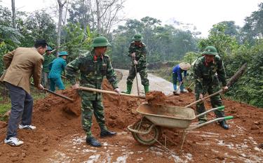 Cán bộ, chiến sĩ lực lượng vũ trang huyện Văn Chấn giúp dân tu sửa đường giao thông nông thôn.