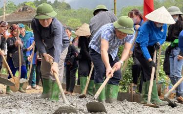 Phó Chủ tịch UBND tỉnh Ngô Hạnh Phúc (trái) tham gia lao động làm đường giao thông tại thôn Đèo Thao, xã Tân Nguyên, huyện Yên Bình.