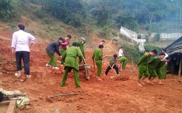 Cán bộ, chiến sĩ, đoàn viên thanh niên Công an huyện Trạm Tấu giúp đỡ hộ gia đình khó khăn tại xã Hát Lừu san gạt nền nhà.