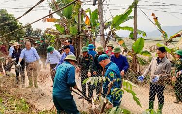 Các đại biểu và nhân dân tiến hành dỡ bỏ tường rào, cây cối, vật kiến trúc để mở rộng đường giao thông.