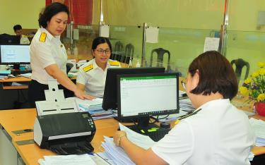 Cán bộ Chi cục Thuế thành phố link dafabet trao đổi về công tác thu nợ thuế.