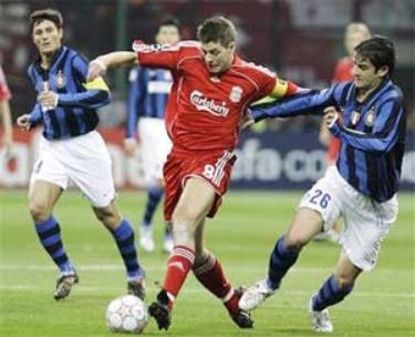 Tiền vệ Steven Gerrard (áo đỏ) đi bóng trước hậu vệ Christian Chivu của Inter Milan.