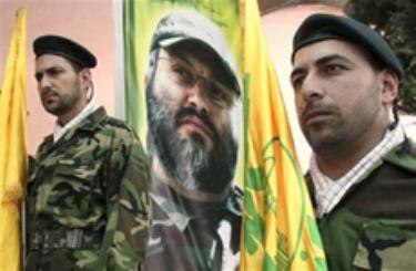 Các thành viên Hezbollah đứng gác trước một bức chân dung vị chỉ huy bị ám Imad Mughniyeh tại làng Tair Dibba, Lebanon hôm 23/3