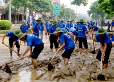 Thanh niên tình nguyện đang nạo vét bùn đất, vệ sinh môi trường tại đại lộ Nguyễn Thái Học, thành phố Yên Bái.