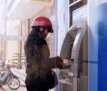 Người dân rút tiền qua thẻ ATM tại các máy rút tiền tự động.
