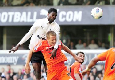 Tiền đạo Emmanuel Adebayor (áo trắng, Tottenham) trong pha không chiến với hàng phòng ngự Swansea.