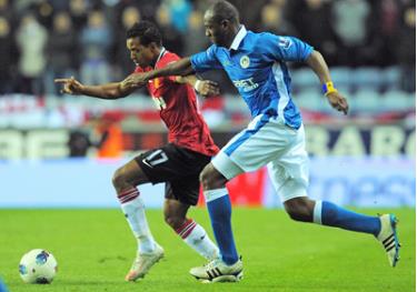 Tiền vệ Nani (áo đỏ, Man.United) nỗ lực thoát khỏi sự đeo bám của hậu vệ Wigan Emmerson Boyce.