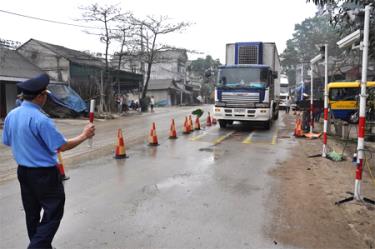 Cán bộ Thanh tra giao thông chỉ dẫn phương tiện giao thông vào Trạm cân.