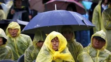 Nhiều người đội mưa chờ đợi lễ tưởng niệm các nạn nhân chìm phà SEWOL tại thành phố Ansan, tỉnh Geyonggi, Hàn Quốc, ngày 16-4-2015. (Ảnh: Reuters)