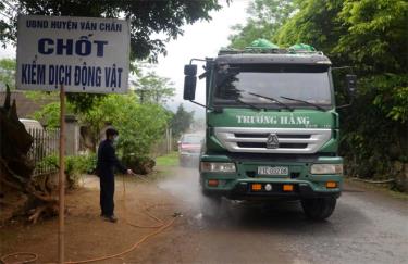 Cán bộ thú y phun tiêu độc khử trùng tại chốt kiểm dịch động vật tạm thời thôn Đá Đỏ, xã Thượng Bằng La, huyện Văn Chấn.