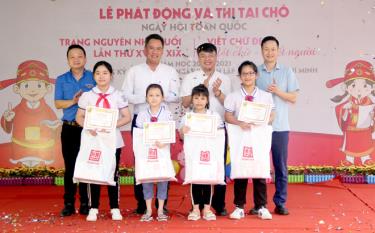 Organisers present four first-place prizes in the handwriting contest.