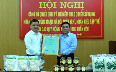 Ông Trần Đức Hợp - Phó Giám đốc Sở Khoa học và Công nghệ (bên phải) trao chứng nhận nhãn hiệu cho 3 sản phẩm nông nghiệp của huyện Trấn Yên.