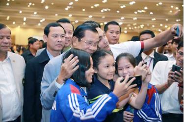 Thủ tướng Hun Sen (đeo kính, trái) chụp hình lưu niệm với một số thành viên Đoàn thể thao Campuchia.