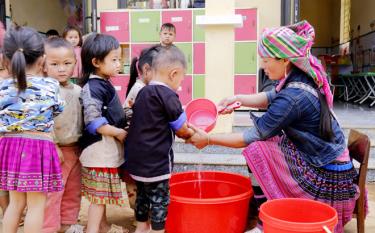 Chị Giàng Thị Lầu - tình nguyện viên điểm trường bản Màng Mủ, Trường Mầm non Mồ Dề hỗ trợ giáo viên vệ sinh cá nhân cho trẻ trước giờ vào lớp.
