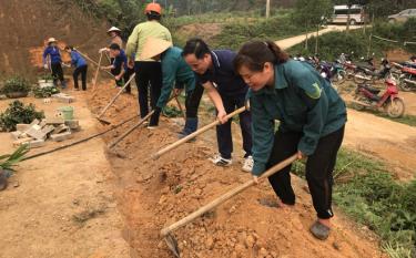 Chiến sĩ dân quân xã Mường Lai tham gia cùng người dân xây dựng khuôn viên nhà văn hóa thôn 1.