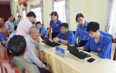 Đồng chí Trần Thị Vân Nga - Bí thư Huyện đoàn Trấn Yên (người thứ 2, phải sang) phối hợp với các đơn vị chức năng hướng dẫn người dân cài đặt ứng dụng VNeID.