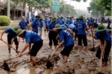 Thanh niên tình nguyện tham gia nạo vét bùn đất, vệ sinh môi trường tại Đại lộ Nguyễn Thái Học, thành phố Yên Bái sau cơn bão số 4 hồi tháng 8 năm 2008.
 (Ảnh: Thanh Chi)

