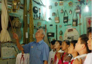 Ông Hà Văn Tích giới thiệu các hiện vật cho các em học sinh trường THCS Hoàng Văn Thọ.
