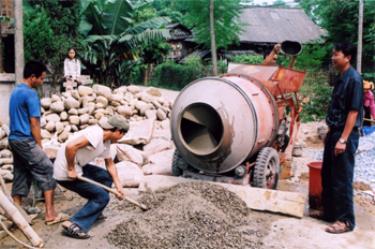 Trưởng khu Lò Văn Cấp (bên phải) đang chỉ đạo bà con thi công đường giao thông trong khu phố.
