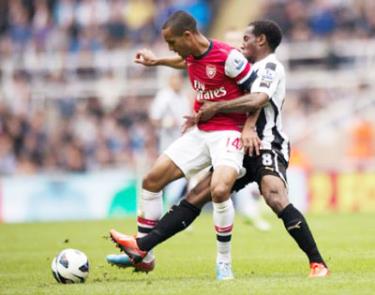 Theo Walcott che bóng trước Vernon Anita của Newcastle.