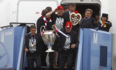 Philip Lahm và HLV Jupp Heynckes cầm theo cúp vô địch bước xuống máy bay.