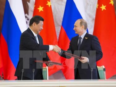 Tổng thống Vladimir Putin (phải) và Chủ tịch Tập Cận Bình (trái) trao đổi văn kiện sau lễ ký các thỏa thuận hợp tác song phương.