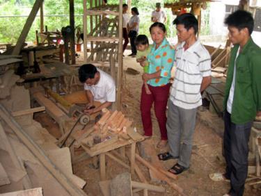 Anh chị Doanh - Hòa (giữa) tại xưởng mộc của gia đình.