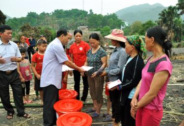 Đồng chí Triệu Tiến Thịnh tiền trao hỗ trợ của tỉnh cho các gia đình bị thiệt hại.