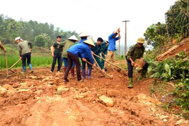 Lực lượng dân quân cơ động của huyện Trấn Yên tham gia cùng nhân dân thôn 9, xã Minh Quán tu sửa đường giao thông nông thôn.
