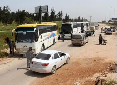 Xe buýt chở các tay súng đối lập từ Damascus tới trạm trung chuyển Rashidin, ngoại ô thành phố Aleppo do Chính phủ kiểm soát ngày 21/4.