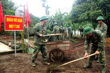 Cán bộ, chiến sỹ Trung đoàn 174 giúp người dân xã Tân Hương vệ sinh môi trường.