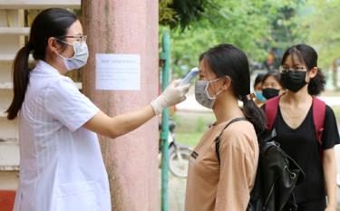 Các em học sinh được đo thân nhiệt trước khi vào lớp.