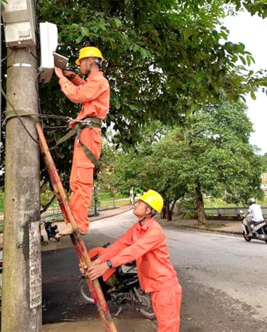 Công nhân Điện lực thành phố Yên Bái kiểm tra, lắp đặt công tơ mới cho khách hàng.