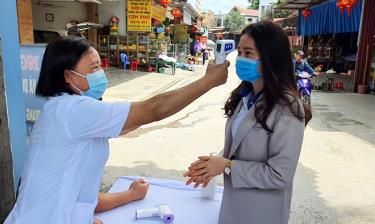 Đo thân nhiệt cho người dân trên bàn xã Đông Cuông, huyện Văn Yên.