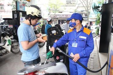 Nhân viên Petrolimex đang bán xăng cho khách hàng.