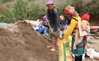 Nhân dân bản Háng Cuốn Rùa, xã Dế Xu Phình giúp nhau vận chuyển cát về láng nền nhà.