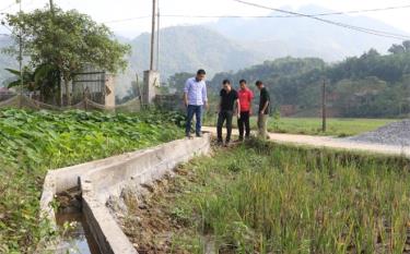 Cán bộ Trung tâm Hỗ trợ phát triển vì phụ nữ và trẻ em và Nhóm nòng cốt tại bản Chao, xã Việt Hồng kiểm tra tiến độ thực hiện Dự án mương bê tông tại bản.