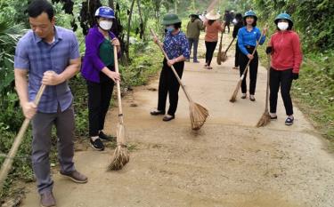 Hội viên phụ nữ xã Ngòi A cùng các tổ chức đoàn thể vệ sinh môi trường đường giao thông liên thôn.