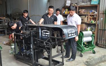 Anh Vũ Văn Ngân (đững giữa) đang giới thiệu chiếc máy bóc vỏ cành quế với lãnh đạo xã dafabet dang nhap Phú. 

