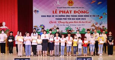Lãnh đạo UBND  thành phố Yên Bái và lãnh đạo Tỉnh đoàn tặng quà trẻ em có hoàn cảnh khó khăn.
