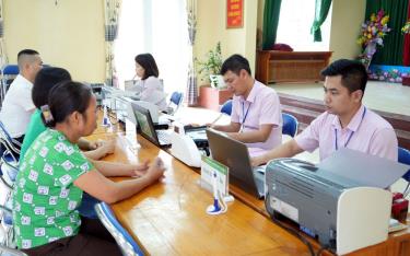 Cán bộ Phòng giao dịch NHCSXH huyện Trấn Yên giải ngân vốn vay tín dụng chính sách tại cơ sở.
