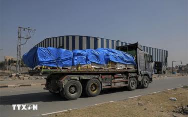 Xe chở hàng viện trợ di chuyển trên tuyến đường ở miền Trung Dải Gaza ngày 21/5.