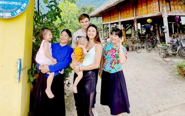 Hoang Thi Xoi, the young proprietor of Xoi Farmstay, poses for a photograph with international guests.