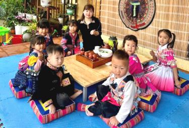 Cô giáo Trường Mầm non Suối Giàng, xã Suối Giàng, huyện Văn Chấn hướng dẫn học sinh cách pha trà và mời trà.