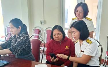 Cán bộ Đội thuế liên huyện Yên Bái - Yên Bình hướng dẫn NNT.
